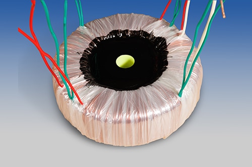 En toroidal transformator med kablar.